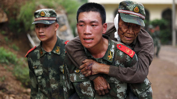 A paramilitary police officer carries an elderly man on his back after an earthquake hit Yunnan province China on Aug. 3. Picture courtesy of The Chicago Tribune